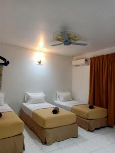 um quarto com 2 camas e uma ventoinha de tecto em ANGGERIK IMPIAN HOTEL -Best for Travellers at Kuala Berang em Kuala Berang