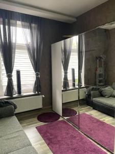 - un salon avec un miroir et un canapé dans l'établissement Schöne Ferienwohnung, à Wilhelmshaven