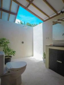 a bathroom with a toilet and a sink at Rumah Tara Gili Air Rooftop Bungalow with Terrace and Whirlpool in Gili Air