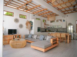 a living room with a couch and a table at Rumah Tara Gili Air Rooftop Bungalow with Terrace and Whirlpool in Gili Air