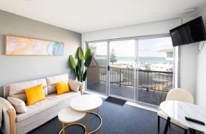 a living room with a couch and a view of the ocean at Mollymook Shores in Mollymook