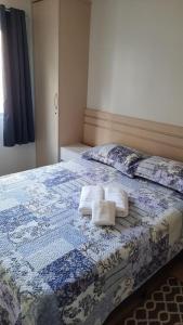 1 dormitorio con 1 cama con 2 toallas en Duas quadras da Praia Rua 2000 WIFI Balneario Camboriu, en Balneário Camboriú