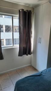 1 dormitorio con cama y ventana en Duas quadras da Praia Rua 2000 WIFI Balneario Camboriu, en Balneário Camboriú