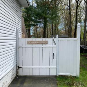 a white gate with a sign on it next to a house at Get Together gt Sylvan Beach, Usa in Sylvan Beach