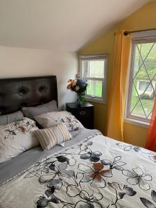 a bedroom with a bed with a floral bedspread at Get Together gt Sylvan Beach, Usa in Sylvan Beach