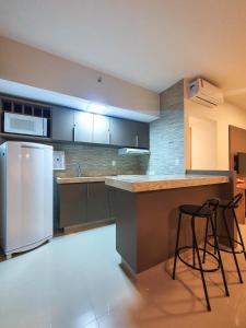 eine Küche mit einem Kühlschrank und 2 Barhockern in der Unterkunft Park Veredas com acesso ao rio no fundo in Rio Quente