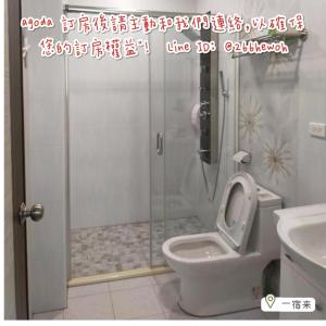 uma casa de banho com um chuveiro, um WC e um lavatório. em 一宿來民宿 em Fengping