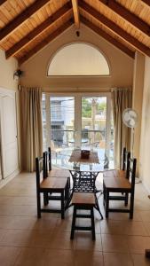 a dining room with tables and chairs and a large window at Los Balcones Madryn in Puerto Madryn