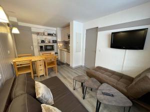 uma sala de estar com um sofá e uma sala de jantar em Appartement Plagne 1800, 2 pièces, 4 personnes - FR-1-181-2708 em La Plagne Tarentaise