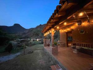 a house with a wooden deck with lights on it at Cabaña en Malinalco El rincón de Anita in Malinalco