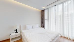 a white bedroom with a white bed and a window at vinhomes metropolis 3 phòng ngủ in Hanoi