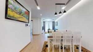 a dining room with a table and white chairs at vinhomes metropolis 3 phòng ngủ in Hanoi