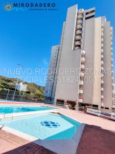 a building with a swimming pool in front of a building at Condominio Nuevo Rodadero, wifi piscina parqueadero in Santa Marta