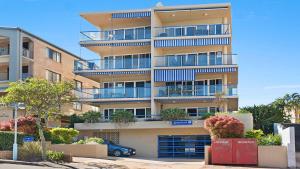 un edificio de apartamentos alto con un coche aparcado delante de él en Boardwalk Apartments Unit 3 Bulcock Beach QLD, en Caloundra