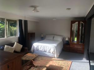 1 dormitorio con 1 cama y 1 sofá en Spiral Gardens Country Park Retreat, en Raurimu