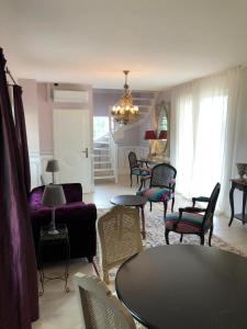 uma sala de estar com um sofá, uma mesa e cadeiras em Cottage Jardin Duplex of 70 m² for 2 people – 1 bedroom – 2 bathrooms – em Azay-le-Rideau