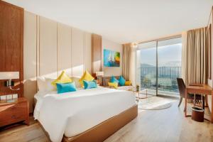 a bedroom with a large white bed and a desk at Panorama Nha Trang in Nha Trang