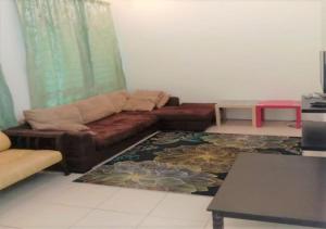 a living room with a couch and a table at Samarahan Homestay 3-bedrooms house in Kuching