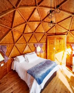 1 dormitorio con 1 cama grande en una habitación de madera en Domos lago Muisca Xue, en Aquitania