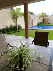 eine Terrasse mit einem Tisch, Stühlen und einem Pool in der Unterkunft Quinta BarLó in General Zuazua