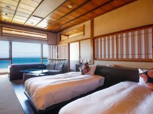 two beds in a room with a view of the ocean at Awaji Yumesenkei in Sumoto