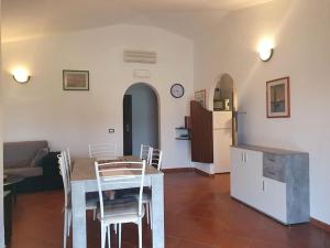una cucina e un soggiorno con tavolo e frigorifero di Villa Capodorso, Palau Porto Pollo a Palau