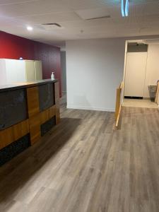 una stanza vuota con pavimento in legno e parete bianca di Garden Hostel ad Auckland Altre 37 foto