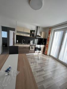 a large kitchen with a wooden floor and a large window at BacherlHouse - Apt Schönbach in Schörfling
