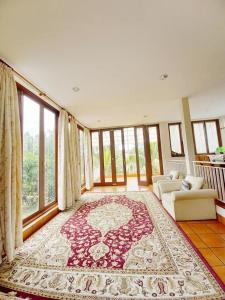 uma sala de estar com um grande tapete no chão em Villa Gathering Yuni Syahla em Citaringgul 1