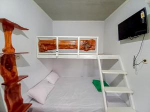 Mały pokój z łóżkiem piętrowym i telewizorem w obiekcie Labinda Homestay Caruban Mitra RedDoorz w mieście Madiun