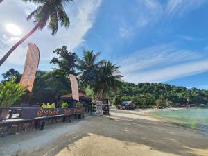a beach with a sign that reads what the beach at Ombak Dive Resort Perhentian Island in Perhentian Islands