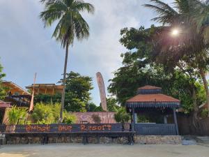 a bench in a park with a monument in the background at Ombak Dive Resort Perhentian Island in Perhentian Islands
