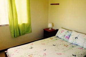 een slaapkamer met een bed met een bloemrijke sprei en een raam bij Villa Pointe Aux Cannoniers in Pointe aux Cannoniers