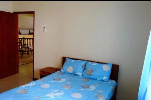 Schlafzimmer mit einem Bett mit blauer Decke in der Unterkunft Villa Pointe Aux Cannoniers in Pointe aux Cannoniers