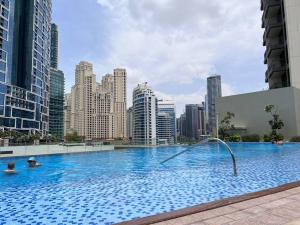 a large swimming pool with a city skyline in the background at Blu Water Luxury Tow Bedroom Apartment - Marina in Dubai