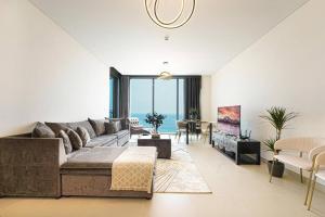 a large living room with a couch and a table at Blu Water Luxury Tow Bedroom Apartment - Marina in Dubai