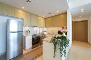 a kitchen with a refrigerator and a counter with plants at Blu Water Luxury Tow Bedroom Apartment - Marina in Dubai