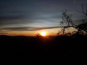 una puesta de sol con la puesta de sol en la distancia en Eagle View villa en Ella