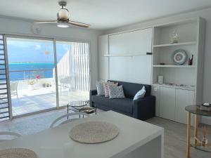 a living room with a couch and a view of the ocean at Studio Deluxe in Bora Bora
