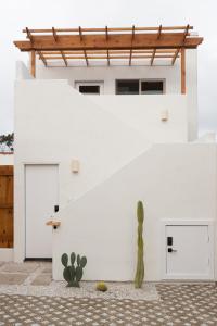 a white building with two garage doors and a cactus at The Laurel Loft in San Diego