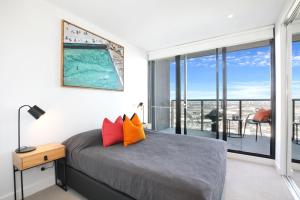 a bedroom with a bed and a balcony at Orange Stay at Collins Wharf in Melbourne +42 photos