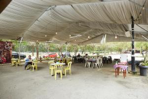 um grupo de pessoas sentadas em mesas sob uma grande tenda em Terengganu Equestrian Resort em Kuala Terengganu