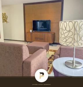 a living room with two couches and a tv at SPACIOUS 2BR NEAR MOA, SOLAIRE CASINO AND PASAY AREA in Manila