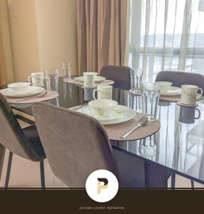 馬尼拉的住宿－SPACIOUS 2BR NEAR MOA, SOLAIRE CASINO AND PASAY AREA，餐桌,带椅子和盘子及杯子