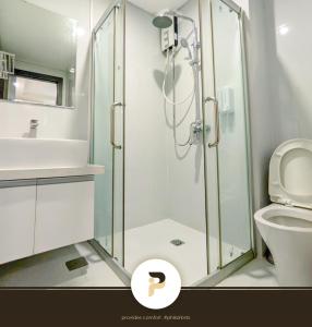 a bathroom with a shower with a toilet and a sink at SPACIOUS 2BR NEAR MOA, SOLAIRE CASINO AND PASAY AREA in Manila