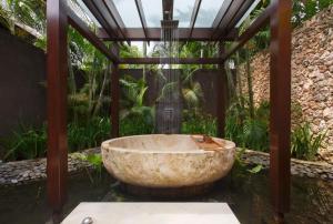 a bath tub in the middle of a garden at The Ungasan Clifftop Resort in Uluwatu