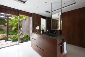 a bathroom with a sink and a large mirror at The Ungasan Clifftop Resort in Uluwatu