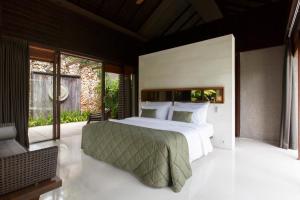 a bedroom with a large bed and a large window at The Ungasan Clifftop Resort in Uluwatu