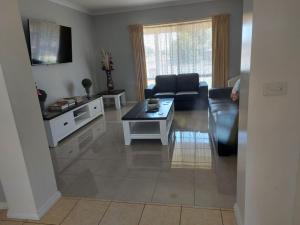 a living room with a couch and a table at Numurkah Self Contained Apartments - The Saxton in Numurkah