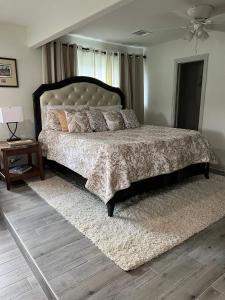1 dormitorio con 1 cama grande y 1 alfombra en Kingwood Cottage - 10 mins from IAH - Lake Front, en Humble